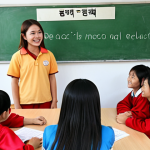 **

A brightly lit classroom scene. Students are actively engaged in a lesson about ethics, discussing honesty and empathy. The teacher is smiling and encouraging participation. In the background, a poster displays the Vietnamese phrase "Đạo đức là nền tảng" (Morality is the foundation).  The overall feel should be warm and positive, emphasizing the importance of moral education.

**